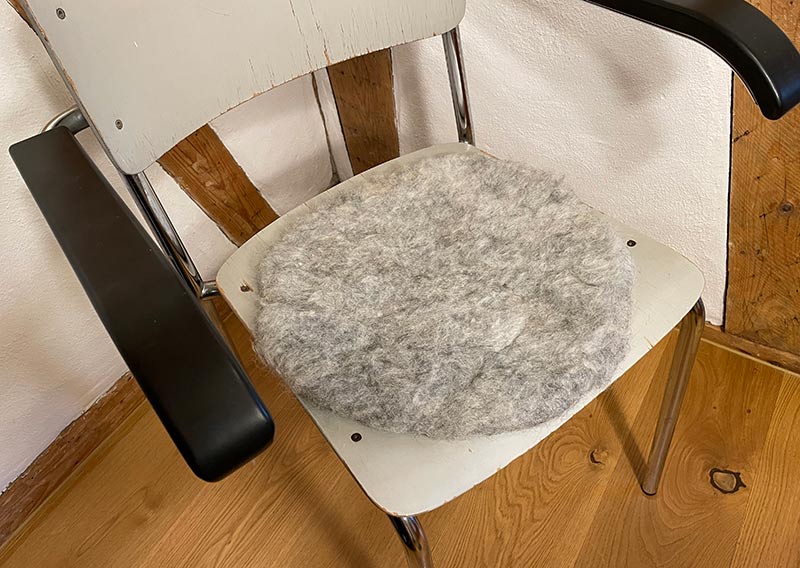 Grau melierte Wolle liegt eher selten auf meinem Filztisch. Diese hier kommt von einer Skudde gleich aus dem Nachbarsdorf. Das leichte Sitzfell ist eher flach und wirkt eleganter und feiner. Bei den Sitzfellen geht es nicht nur um die Zierde eines Stuhls, sonder auch um den unvergleichlichen Sitzkomfort und Behaglichkeit. Einmal probiert für immer verliebt.